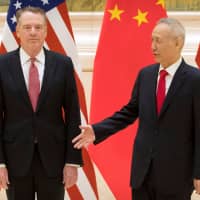 Chinese Vice Premier and lead trade negotiator Liu He reaches to shake hands with U.S. Trade Representative Robert Lighthizer before the opening session of trade negotiations in Beijing on Thursday. | REUTERS