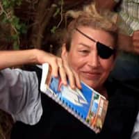 Journalist Marie Colvin poses for a photograph with Libyan rebels (unseen) in Misrata in 2011. | REUTERS
