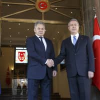 Turkish Defense Minister Hulusi Akar (right) and Russian Defense Minister Sergei Shoigu pose for a photo during their meeting in Ankara Monday. Shoigu said at the start of Monday\'s meeting with his Turkish counterpart Akar that the two countries\' experts have done \"a lot of work to coordinate on issues related to the stabilization in Idlib and issues related to the east bank of the Euphrates River.\" | VADIM SAVITSKY, RUSSIAN DEFENSE MINISTRY PRESS SERVICE / VIA AP