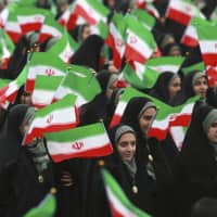 Iranians wave national flags during a ceremony celebrating the 40th anniversary of the Islamic Revolution, at the Azadi Square in Tehran on Monday. | AP