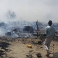 In this photo taken Feb. 7 and provided by the International Rescue Committee (IRC), internally displaced persons look at destroyed houses following a fire at a camp for those who had fled fighting in surrounding areas, in Monguno town, Borno State, northeastern Nigeria. Nigeria\'s government acknowledges an extremist resurgence by Boko Haram offshoot in the Islamic State West Africa Province, and the renewed extremist violence may threaten the validity of Saturday\'s election in the northeast. | DEBORAH PETER / INTERNATIONAL RESCUE COMMITTEE / VIA AP