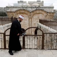 An Muslim cleric checks a gate, closed by Israeli Police, at the Al Aqsa mosque compound in Jerusalem\'s Old City on Feb. 18. | AFP-JIJI
