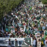 Supporters and activists of the Tehreek-e-Labbaik Pakistan party march during an anti-Indian protest in Karachi on Sunday. Indian authorities arrested dozens of Muslim leaders in raids across Kashmir and sent thousands of reinforcements to the troubled territory on Friday as Prime Minister Narendra Modi stepped up warnings to Pakistan over a suicide bomb attack. | AFP-JIJI