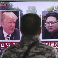 A man watches a TV screen showing images of U.S. President Donald Trump and North Korean leader Kim Jong Un during a news program at the main railway station in Seoul on Saturday. | AP