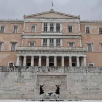 Presidential guards perform in front of the Greek Parliament building in Athens on Thursday. | AFP-JIJI