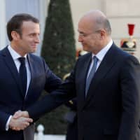 French President Emmanuel Macron (left) greets Iraqi President Barham Salih for talks at the Elysee Palace in Paris Monday. | REUTERS