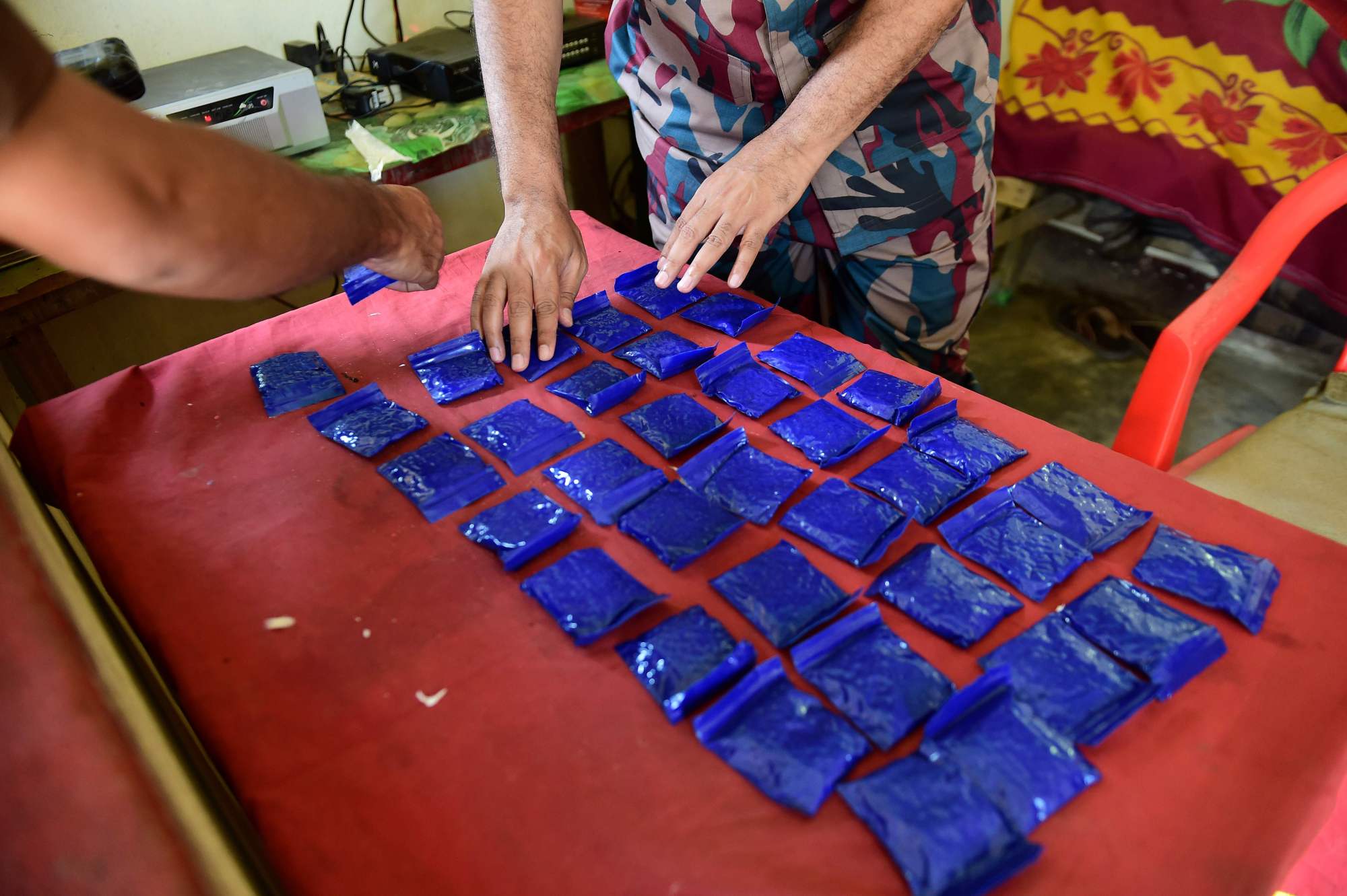 A Bangladesh border guard lays out small bags of the drug yaba (a mixture of methamphetamine and caffeine) recovered from a passenger bus during a search at a checkpoint on the Teknaf-Cox's Bazar highway in Teknaf. The authorities in Bangladesh seized a record 53 million methamphetamine pills in 2018 &#8212; up 33 percent in a year &#8212; officials said on Sunday. | AFP-JIJI