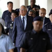 Former Malaysian Prime Minister Najib Razak walks out of a courtroom at the Kuala Lumpur High Court in October last year. | AP