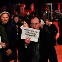 People protest Netflix before they attend the premiere of the film \"Elisa and Marcela\" at the 69th Berlinale film festival on Wednesday in Berlin. | AFP-JIJI