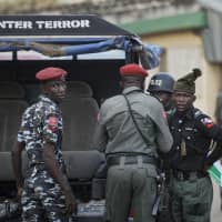 Counterterror and regular police provide security at the offices of the Independent National Electoral Commission in Kano, northern Nigeria, Thursday. Nigeria\'s main opposition party charged Thursday that the election commission has kept more than 1 million ghost voters on the national register, raising fears of vote-rigging ahead of Saturday\'s presidential election. | AP