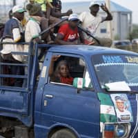 Youth supporters of President Muhammadu Buhari cheer as they return from a rally of the ruling All Progressives Congress party, near the offices of the Independent National Electoral Commission in Kano, northern Nigeria, Thursday. | AP