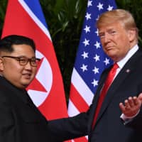U.S. President Donald Trump meets with North Korean leader Kim Jong Un at the start of their first summit, in Singapore last June. | AFP-JIJI