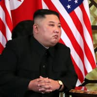 North Korean leader Kim Jong Un listens as U.S. President Donald Trump speaks ahead of a one-on-one bilateral meeting at the second North Korea-U.S. summit in Hanoi on Thursday. | REUTERS