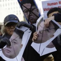 South Korean protesters and North Korean defectors tear portraits of North Korean leader Kim Jong Un during a rally near the U.S. Embassy in Seoul. The protesters were urging the United States to discuss North Korean human rights issues in the summit between U.S. President Donald Trump and Kim. | AP