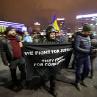 Protesters carry a banner during a demonstration against judicial changes in Bucharest Sunday. | INQUAM PHOTOS / GEORGE CALIN / VIA REUTERS