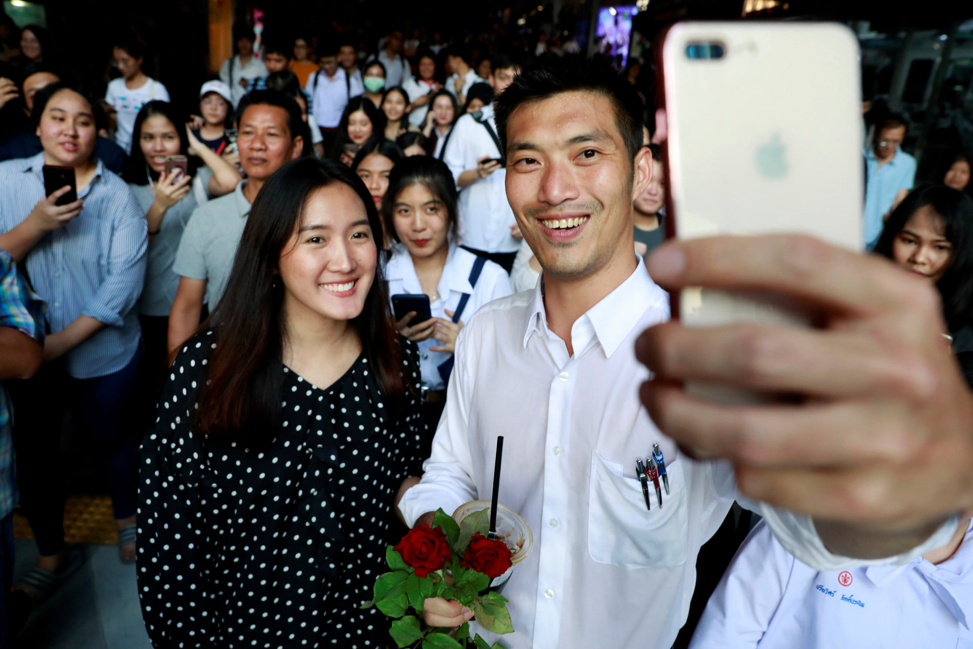 Thanathorn Juangroongruangkit, leader of the Future Forward Party, takes a selfie with his supporters during a campaign rally in Bangkok on Feb. 20. | REUTERS