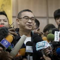 Reungkrai Leekijwatana, an official with the Thai Raksa Chart party, speaks to members of the media at the office of the Election Commission in Bangkok on Monday. | BLOOMBERG