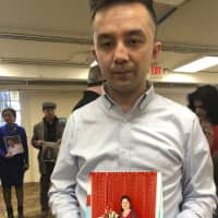 Ferkat Jawdat holds up a photo of his mother during a gathering to raise awareness about loved ones who have disappeared in China\'s far west, in Washington on Sunday. In recent years, Xinjiang has been subject to a severe security crackdown that the Chinese government says is necessary to fight latent religious extremism. | AP