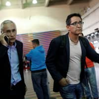 Jorge Ramos, anchor of Spanish-language U.S. television network Univision, talks on a mobile phone as he arrives at the Simon Bolivar international airport in Caracas Tuesday before leaving Venezuela. | REUTERS