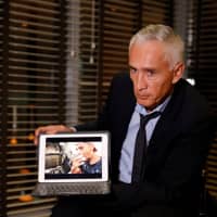 Jorge Ramos, anchor of Spanish-language U.S. television network Univision, shows a video of young Venezuelans eating from a garbage truck, while talking to the media in Caracas Monday. | REUTERS