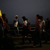 People cross the Simon Bolivar bridge from Venezuela before sunrise at Cucuta, Colombia, on Tuesda. Eleven governments from the Lima Group of nations, which includes Brazil, Canada, Chile and Colombia, issued a joint declaration urging the Venezuelan National Armed Forces not to impede the entry and transit of humanitarian aid to the Venezuelan people. | BLOOMBERG