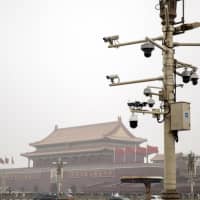 Surveillance cameras are mounted on a post at Tiananmen Square as snow falls in Beijing on Thursday. | BLOOMBERG