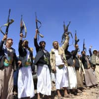 Armed Yemeni men raise their weapons as they gather near the capital Sanaa to show their support to the Shiite Huthi movement against the Saudi-led intervention, on Thursday. | AFP-JIJI