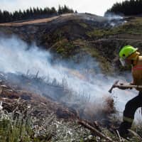 New Zealand Defence Force firefighters combat the Richmond fire near Nelson, South Island, on Friday. | NEW ZEALAND DEFENCE FORCE/VIA REUTERS