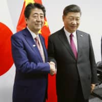 Prime Minister Shinzo Abe and Chinese President Xi Jinping shake hands at the outset of their talks on the sidelines of the Group of 20 summit in Buenos Aires in November. | POOL / VIA KYODO