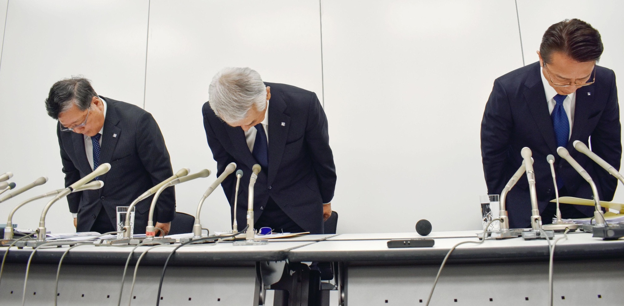 Leopalace21 Corp. CEO Eisei Miyama (center) and other executives bow to apologize for defects found in 1,324 apartments during a news conference Thursday in Tokyo. | KYODO