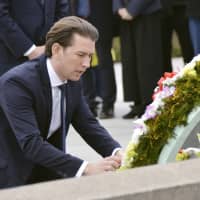Visiting Austrian Chancellor Sebastian Kurz lays flowers at the cenotaph for atomic bomb victims at Peace Memorial Park in Hiroshima on Saturday. | KYODO