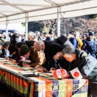 Well-wishers sign greeting books honoring the 30th anniversary of the enthronement of Emperor Akihito at the Imperial Palace in Tokyo on Sunday. | AFP-JIJI