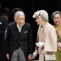 Emperor Akihito and Empress Michiko leave the stage after a ceremony held to mark the 30th year of his reign, at the National Theatre in Tokyo on Sunday. | AP