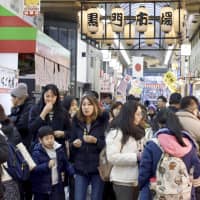 Tourists pack the popular Kuromon food market in Osaka. The estimated number of foreign guests at hotels and other types of accommodations in Japan hit a record 88.59 million in 2018. | KYODO
