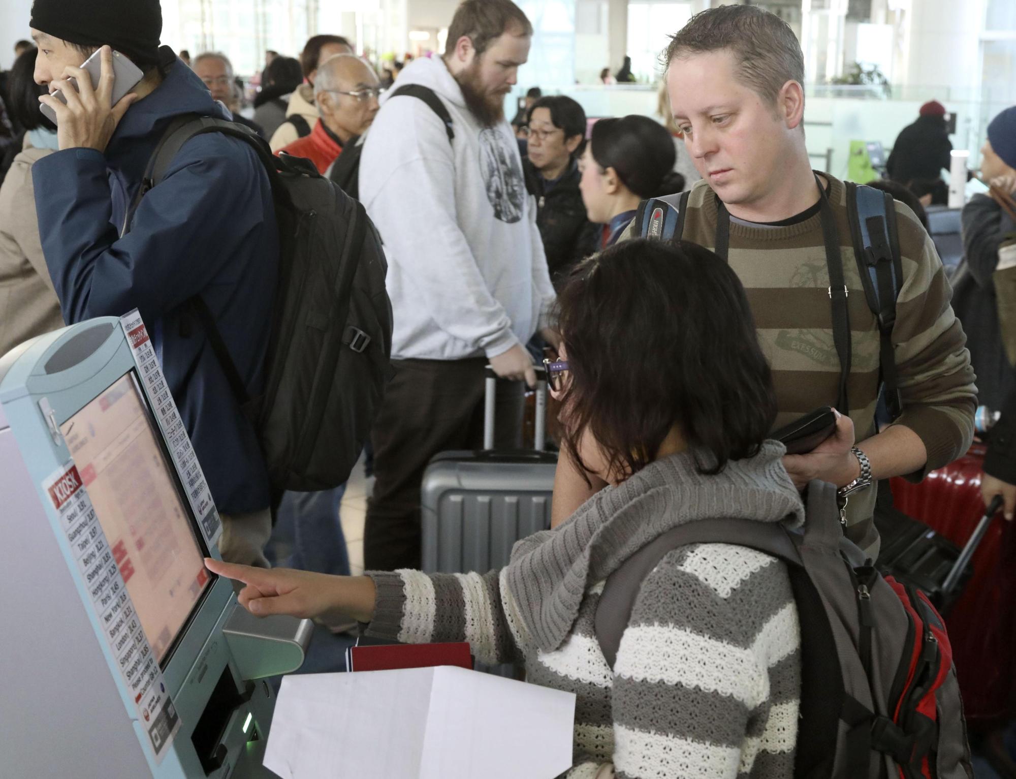 Passengers check in for international flights at Haneda airport in Tokyo. | KYODO