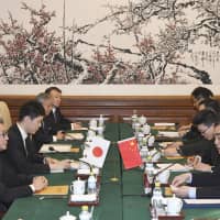 Delegates from Japan and China discuss bilateral security issues at a meeting in Beijing on Friday. | KYODO