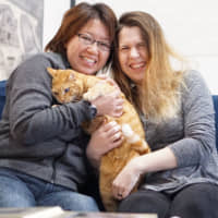 Ai Nakajima (left) and her partner, Kristina Baumann, pose at their home in Yokohama on Monday. The couple is planning to file a lawsuit in a bid to have their marriage recognized in Japan. | MAGDALENA OSUMI