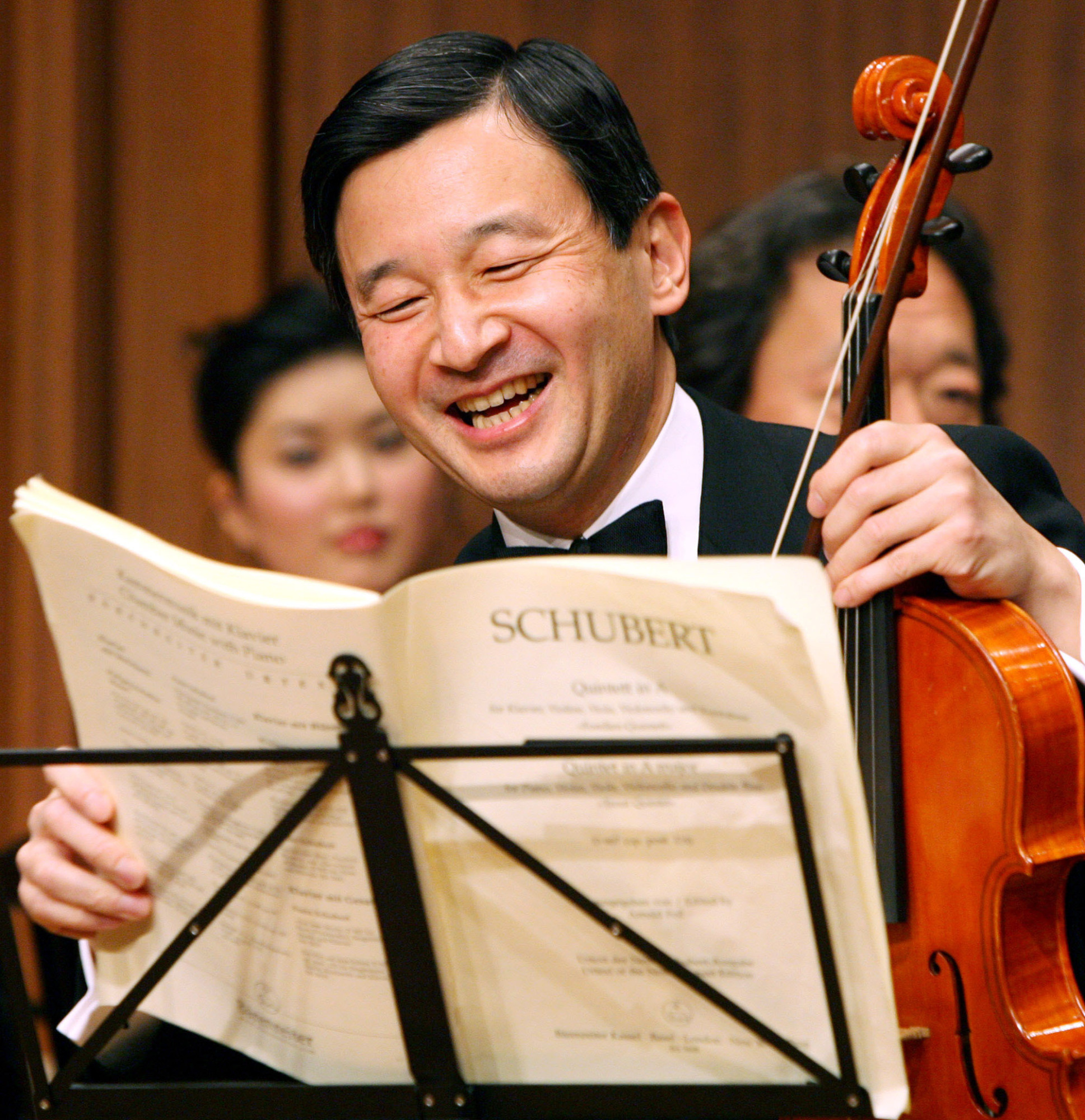 Crown Prince Naruhito laughs as he prepares to play the viola during a photo session before a friendship concert with famous Asian artists in Tokyo in January 2007.