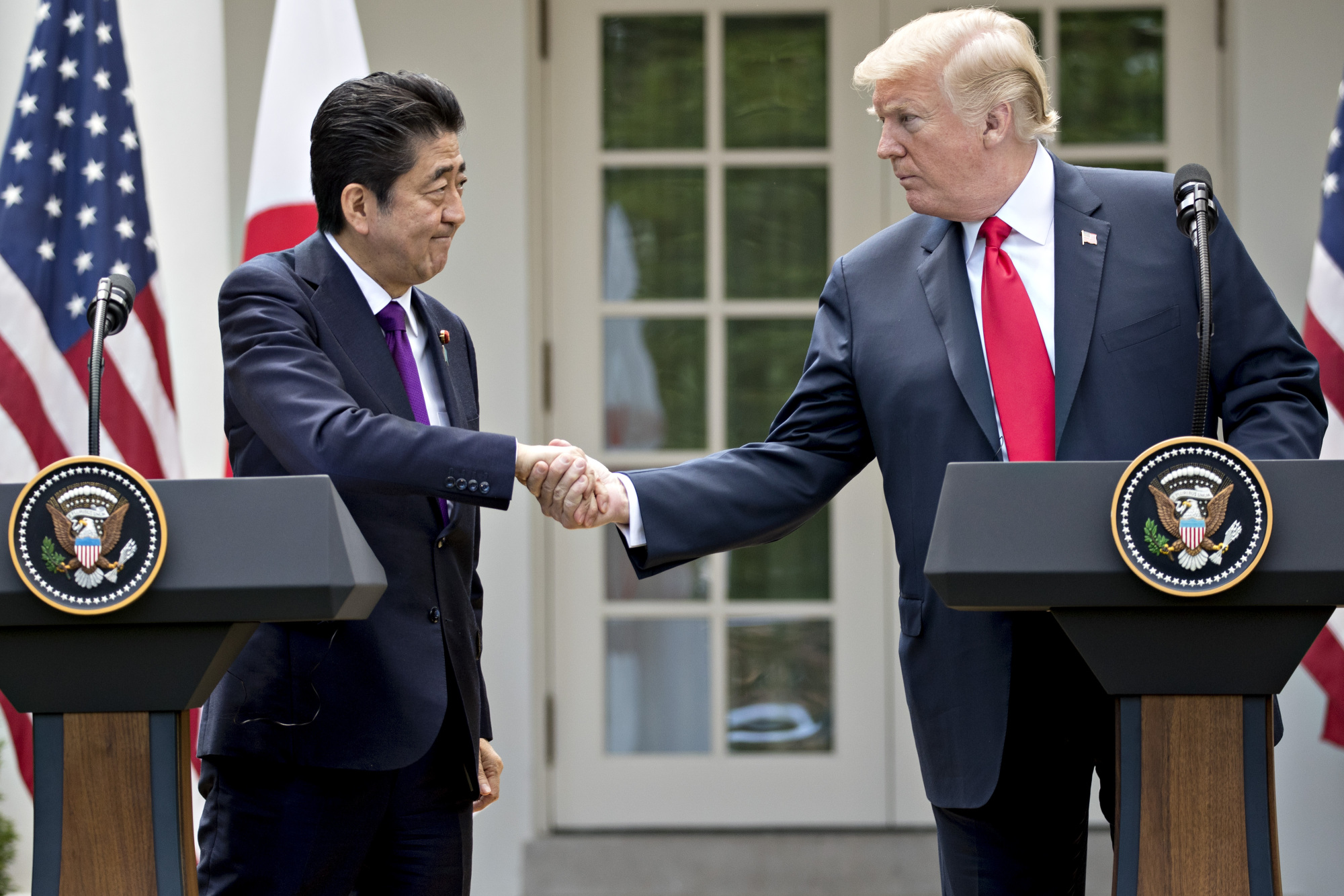Prime Minister Shinzo Abe shakes hands with U.S. President Donald Trump during a news conference in the Rose Garden at the White House last June. | BLOOMBERG