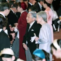 Emperor Akihito and Empress Michiko speak with guests at a tea party they hosted at the Imperial Palace in Tokyo on Tuesday to mark the Emperor’s 30-year reign. | POOL / VIA KYODO