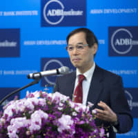 Naoyuki Yoshino, dean of the Asian Development Bank Institute, speaks during the organization\'s annual conference in Tokyo in 2016. | BLOOMBERG