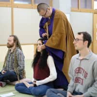 Guests experience Zen meditation at a hostel that used to be the Chonan West Elementary School in Chonan, Chiba Prefecture. D2C X Inc., an operator of a Japan travel information website, promotes tourism in remote areas in Japan, among other tourist spots. | D2C X