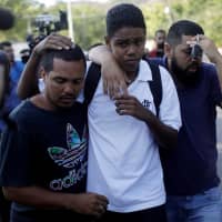 People embrace in front of Flamengo\'s training center after Friday\'s deadly fire in Rio de Janeiro. | REUTERS