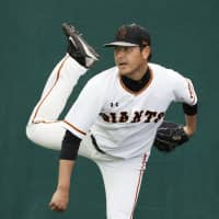 The Giants\' Hisashi Iwakuma pitches during spring camp on Wednesday in Naha, Okinawa Prefecture. | KYODO
