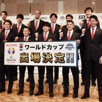 Players and coaches of Japan\'s men\'s basketball team pose for photos at a news conference in Narita, Chiba Prefecture, on Monday night. The Akatsuki Five clinched a berth in this summer\'s FIBA World Cup with a win over Qatar on Sunday on Doha. | KAZ NAGATSUKA