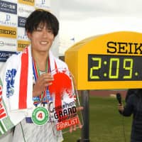 Kohei Futaoka displays his trophy after finishing fourth at the Beppu-Oita Marathon with a time of 2:09:15, qualifying for September\'s Marathon Grand Championship as the race\'s top Japanese runner. | KYODO