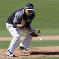 New York Yankees pitcher Masahiro Tanaka fields a ball during a drill at spring training on Thursday in Tampa, Florida. | AP