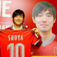 Shoya Nakajima holds up his new Al-Duhail uniform after being officially unveiled by the club on Tuesday in Doha. | AFP-JIJI
