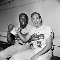 Baltimore Orioles teammates Frank Robinson (left) and Brooks Robinson pose after leading the Baltimore Orioles to a 5-2 win in the opening game of the World Series against the Los Angeles Dodgers, in Los Angeles in 1966. | AP