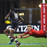 The Sharks\' Aphelele Fassi avoids a tackle by the Sunwolves\' Shane Gates to score a try in their Super Rugby match on Saturday night in Singapore. | AFP-JIJI